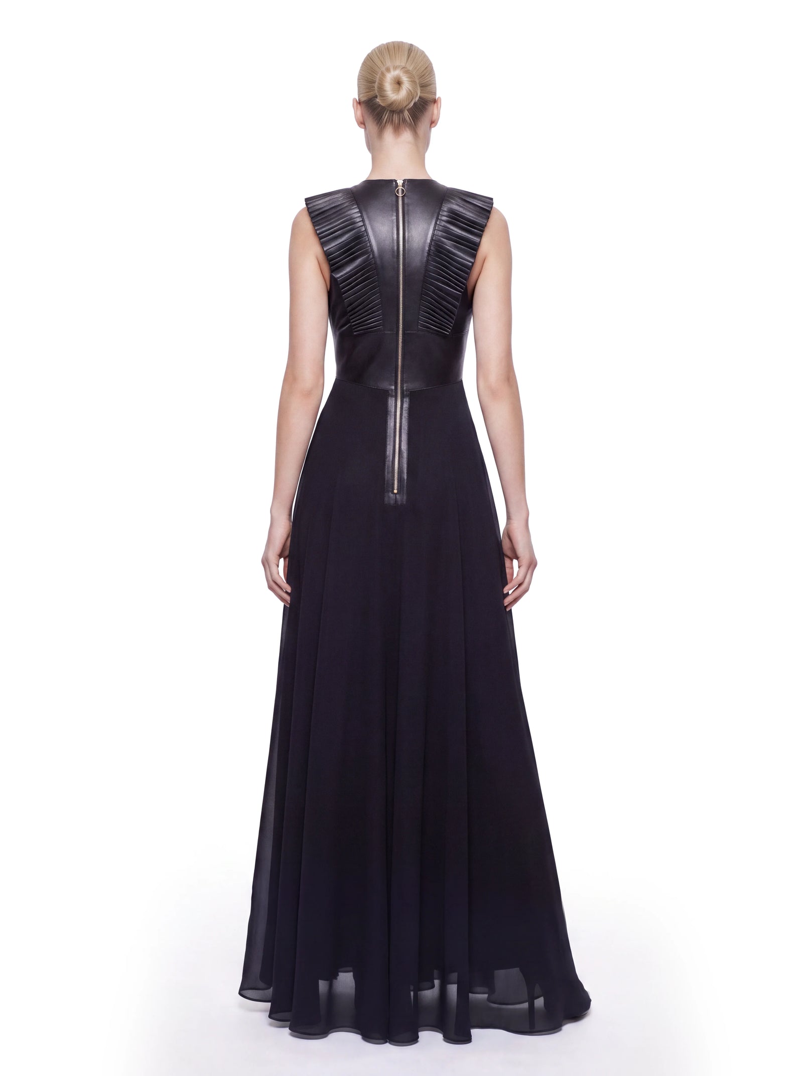 Luxus Designer Abendkleid für Damen in Schwarz mit bodenlangem, fließendem Rock und figurbetontem Oberteil aus Lammleder. Plissierte Lederdetails im Schulterbereich und ein langer Reißverschluss setzen markante Akzente.