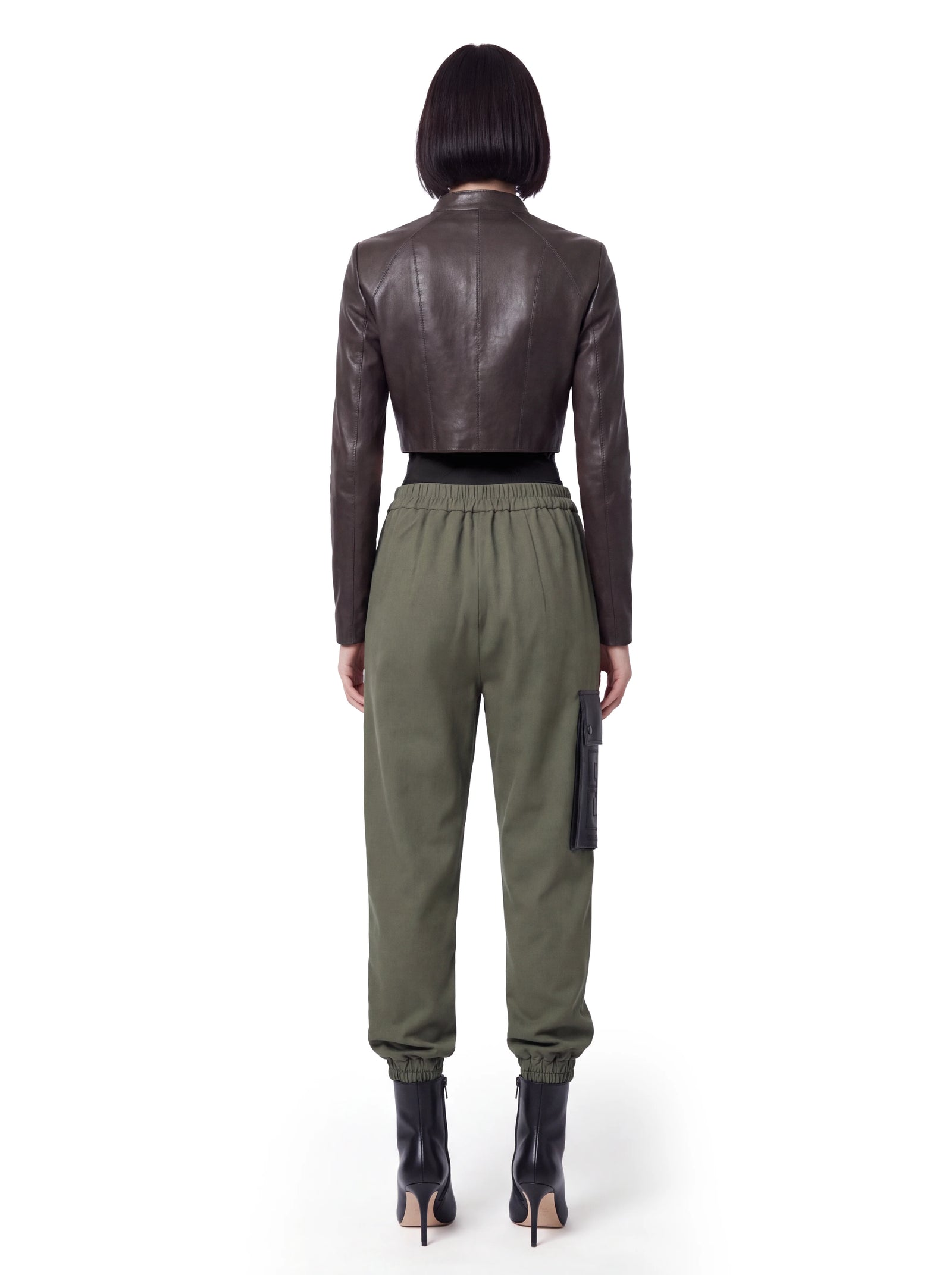Dunkelbraune Luxus Designer Lederjacke in verkürzter Silhouette, gezeigt in der Rückansicht, mit präziser vertikaler Nahtführung, körpernaher Passform und geradem, cleanem Saumabschluss.
