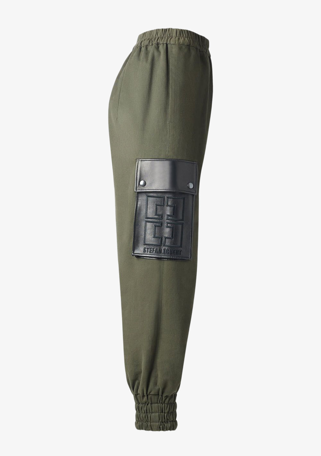 Jogger Pants Khaki für Damen mit Gummizug und Leder-Seitentasche mit Logo-Stickerei von Designer Stefan Eckert. Erhältlich in Hamburg, London, New York, London und Paris. Jogger pants khaki for women with elastic waistband and leather side pocket with logo embroidery by designer Stefan Eckert. Available in Hamburg, London, New York, London and Paris.