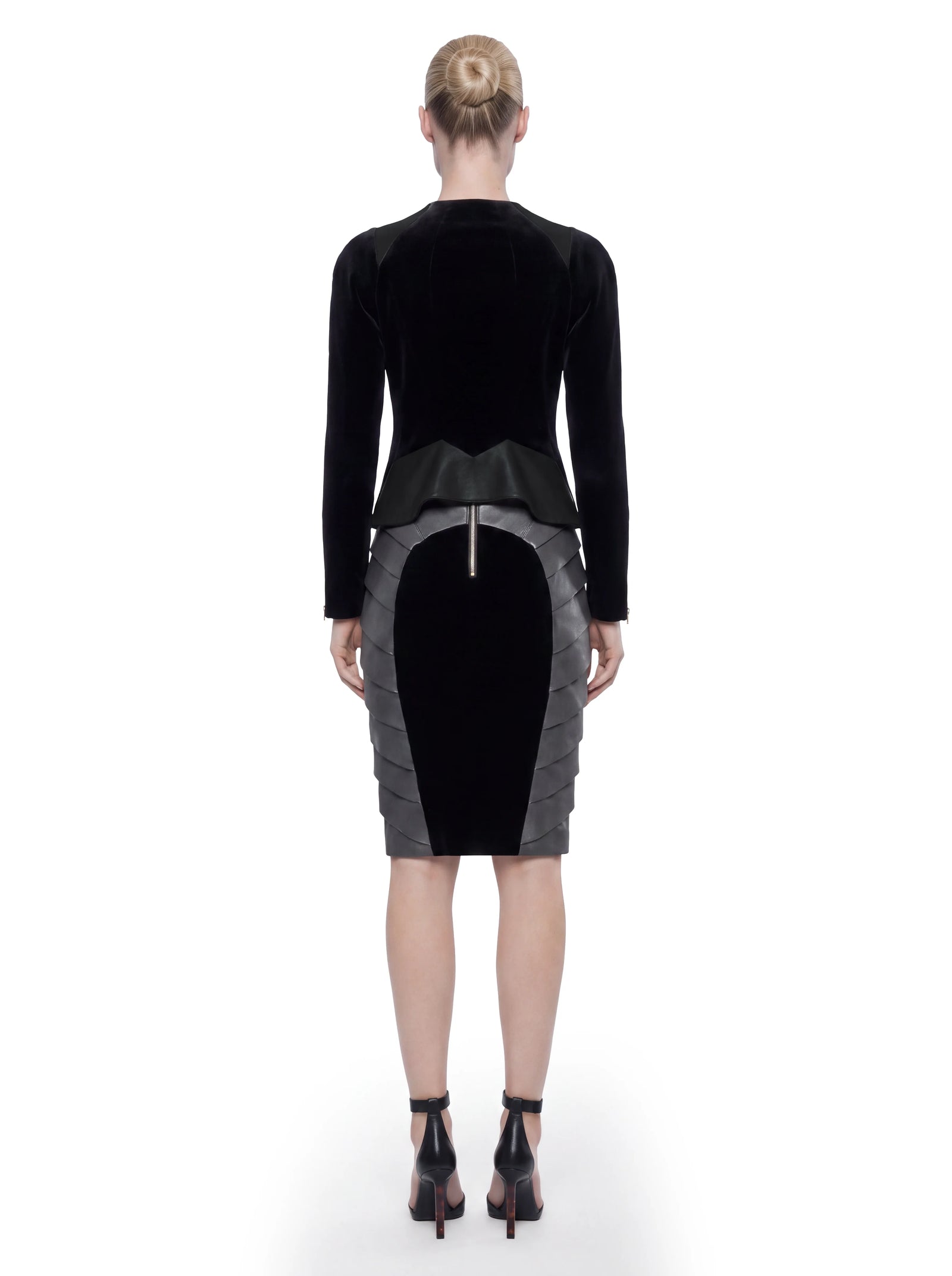 Rückansicht eines Models in schwarzer Designer Lederjacke von Stefan Eckert aus Samt und Lammleder mit skulpturalem Schößchen und taillierter Silhouette.