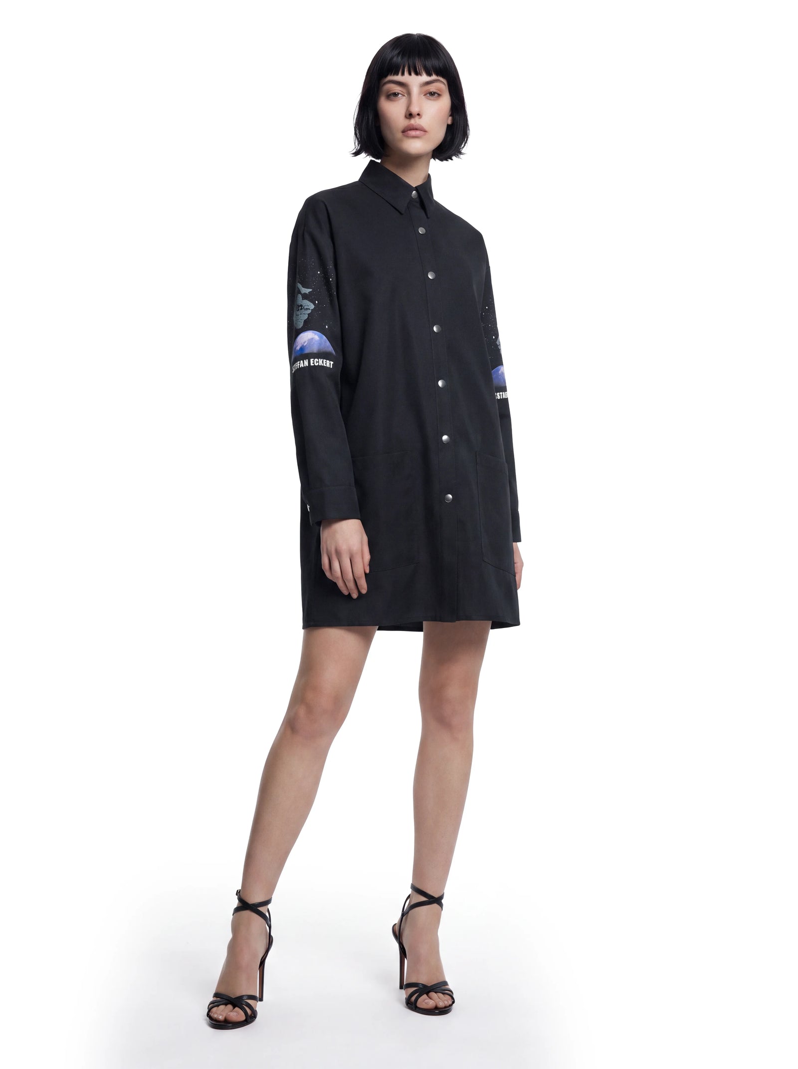Luxus Designer Hemdkleid für Damen aus Baumwolle in Schwarz mit klassischem Kragen, durchgehender Knopfleiste, aufgesetzten Taschen und markanten Printdetails an den Ärmeln.