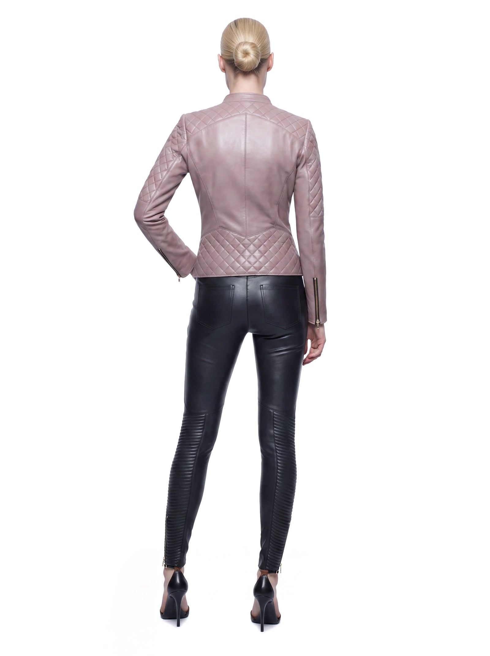 Roséfarbene Luxus Designer Lederjacke in der Rückansicht mit feminin taillierter Silhouette. Rautenförmige Steppungen an Schulterpartie, Ärmeln und unterem Rücken setzen markante Akzente, während präzise Teilungsnähte und goldfarbene Reißverschlüsse an den Ärmelabschlüssen das Design abrunden.