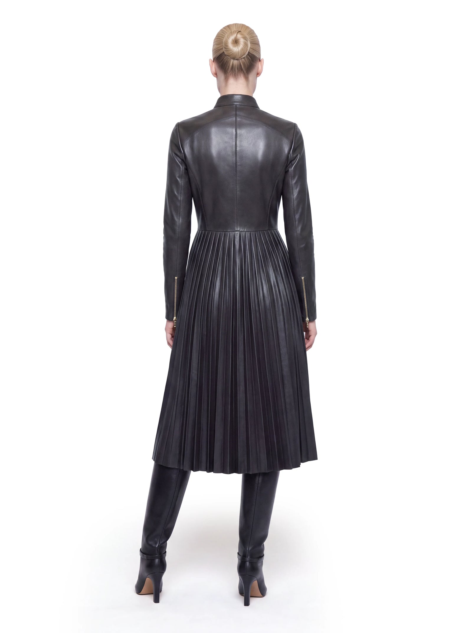 Luxus Designer Ledermantel für Damen aus schwarzem Lammleder mit elegant ausgestelltem Rockteil und präzise gearbeiteten Plisseefalten, die dem Design eine feminine Silhouette verleihen.