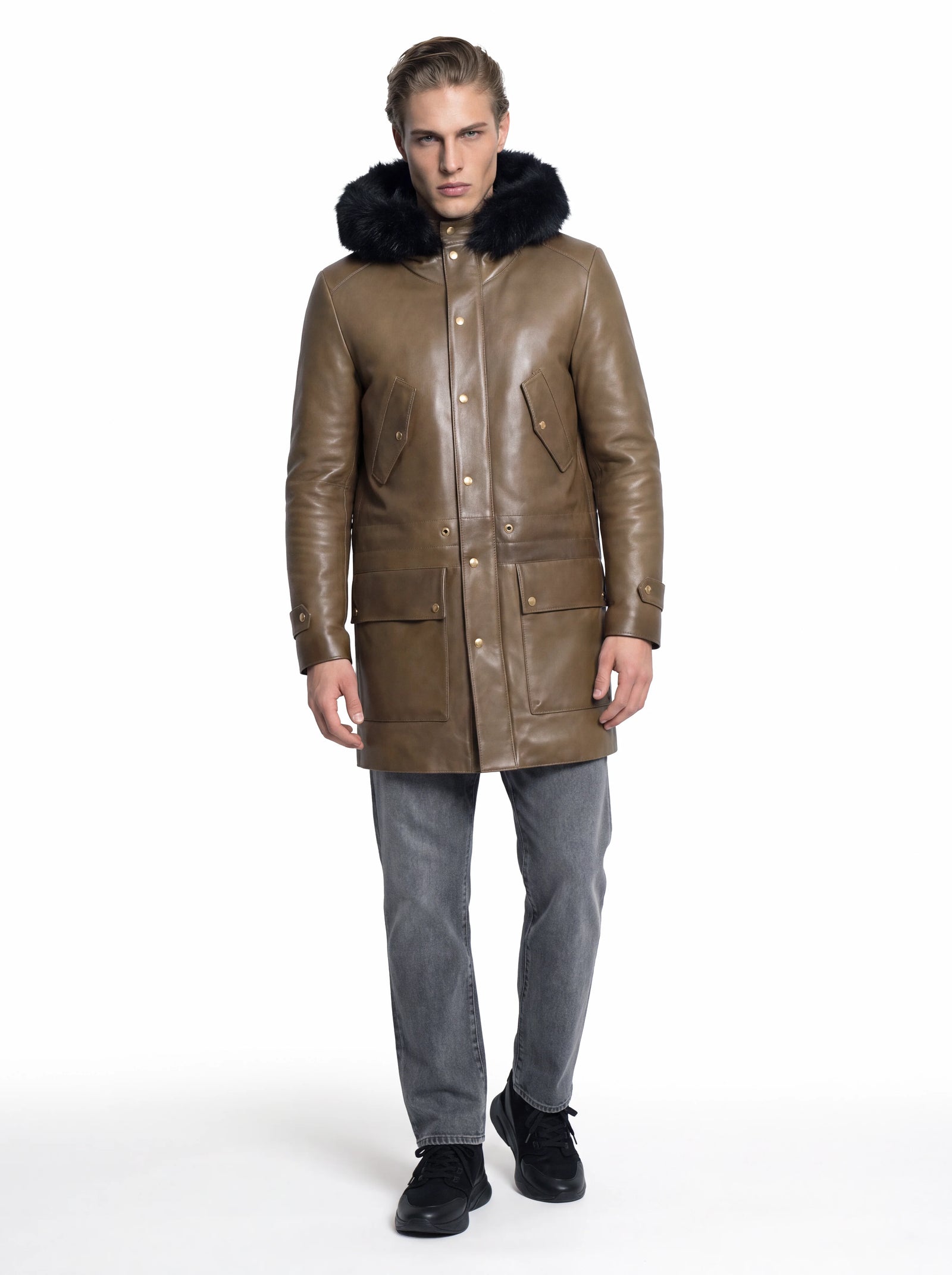 Luxus Designer Parka für Herren aus braunem Leder mit schwarzem Fellbesatz an der Kapuze, goldfarbenen Knöpfen und markanten Pattentaschen.