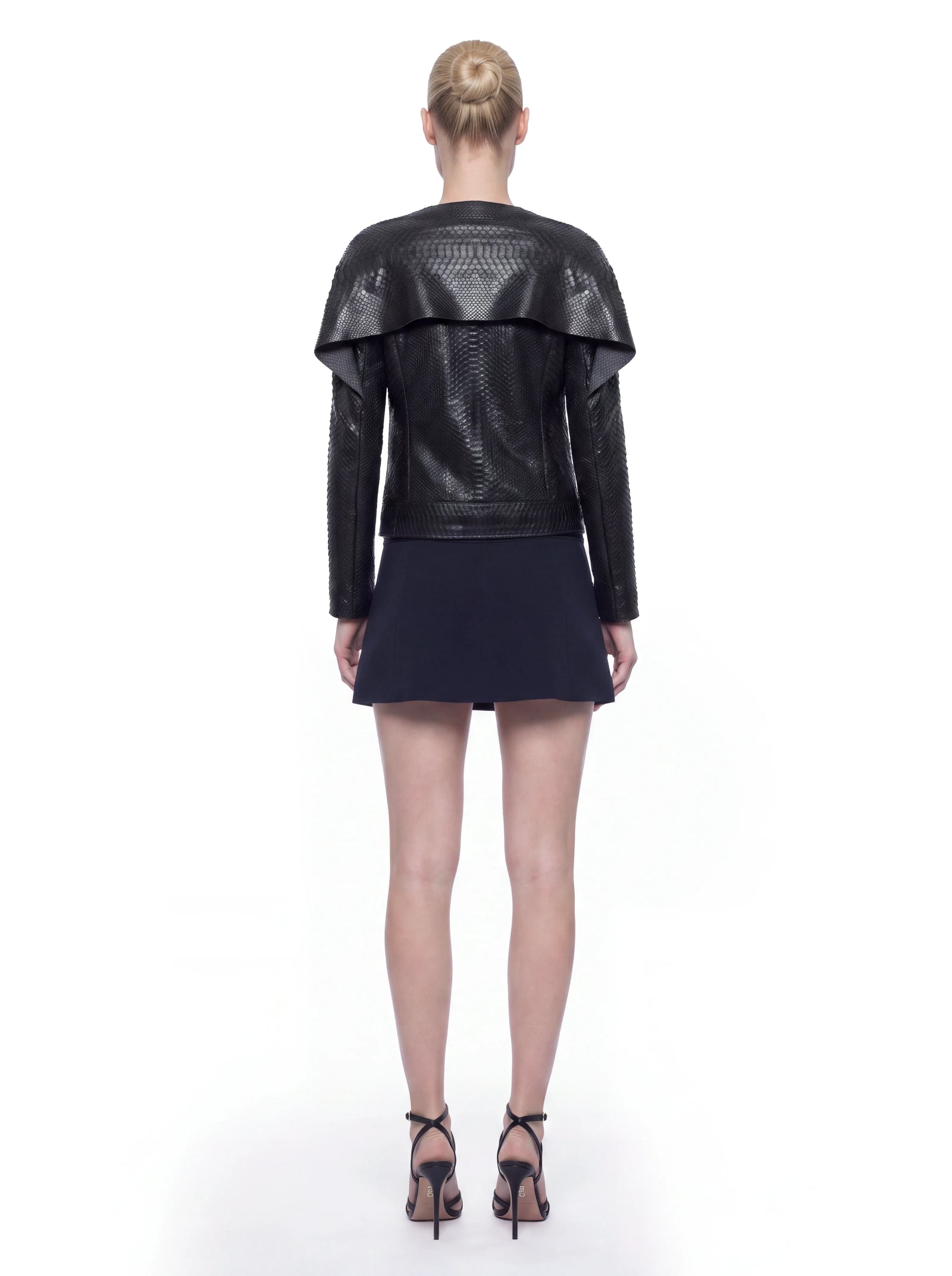 Schwarze Luxus Designer Jacke aus Pythonleder in der Rückansicht mit charakteristischer Schuppenstruktur und markant überlagerter Schulterpartie. Die klare, gerade Silhouette und die großflächige Verarbeitung des exotischen Leders verleihen dem Design eine ausdrucksstarke, exklusive Optik.