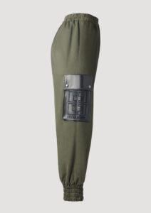 Jogger Pants Khaki für Damen mit Gummizug und Leder-Seitentasche mit Logo-Stickerei von Designer Stefan Eckert. Erhältlich in Hamburg, London, New York, London und Paris. Jogger pants khaki for women with elastic waistband and leather side pocket with logo embroidery by designer Stefan Eckert. Available in Hamburg, London, New York, London and Paris.